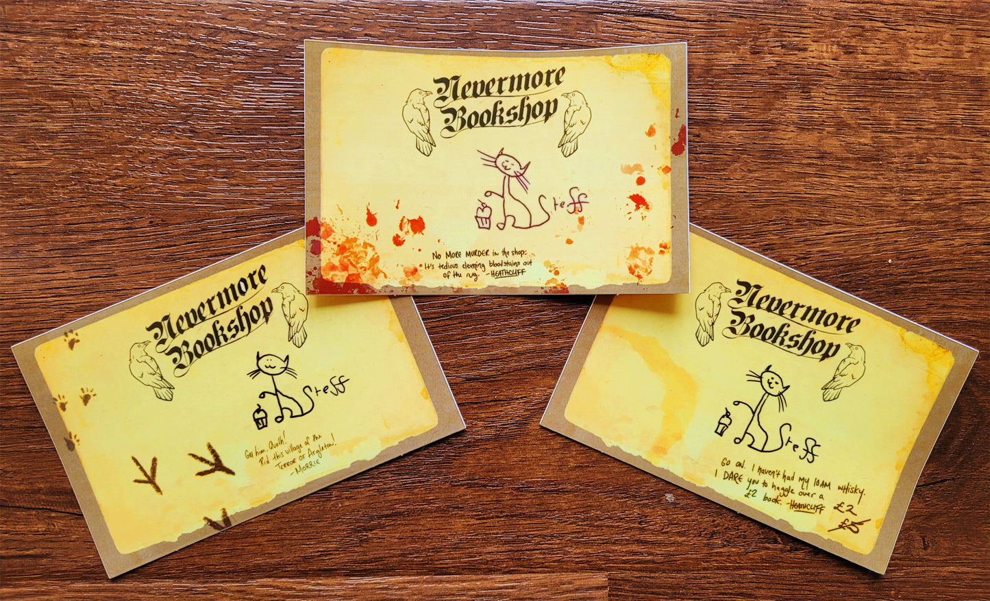 Three illustrated bookplate stickers on a wood background