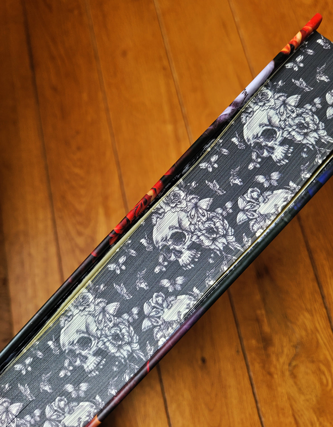 Printed edge of the Poison Ivy hardcover with a skull and flower design