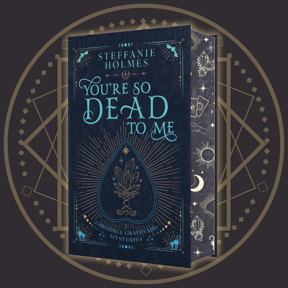 Signed hardcover edition of 'You're So Dead To Me' by Steffanie Holmes, featuring a black cover with gold and teal accents, and illustrations 